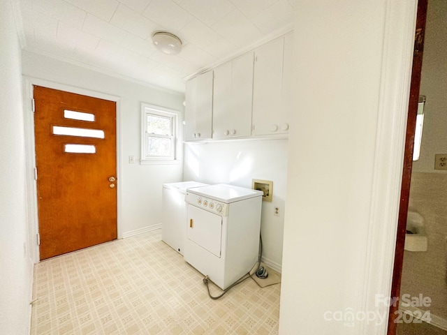 clothes washing area featuring cabinets, crown molding, and washing machine and dryer