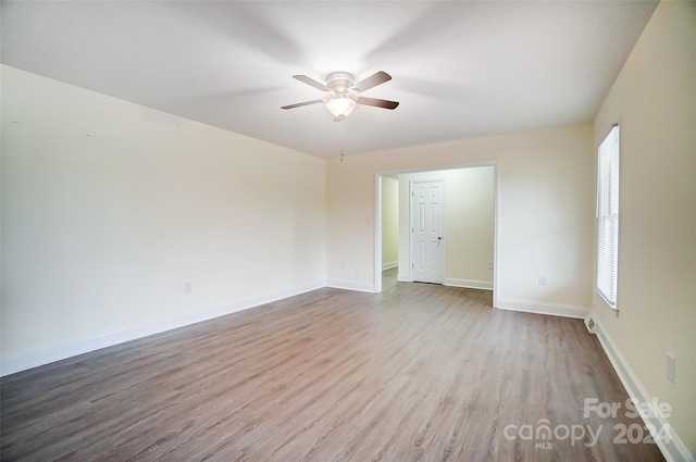 empty room featuring light wood-type flooring, ceiling fan, and a healthy amount of sunlight