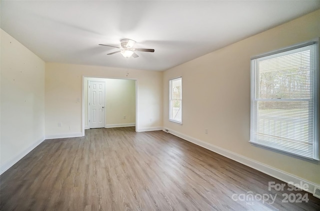 empty room with ceiling fan and light hardwood / wood-style floors