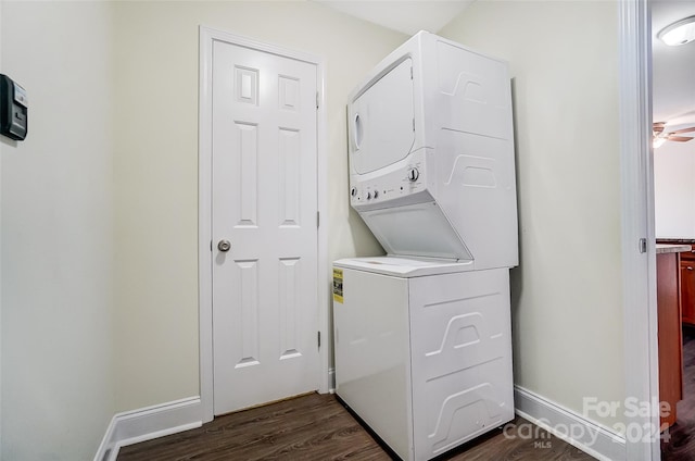 washroom featuring dark hardwood / wood-style floors, stacked washer / dryer, and ceiling fan