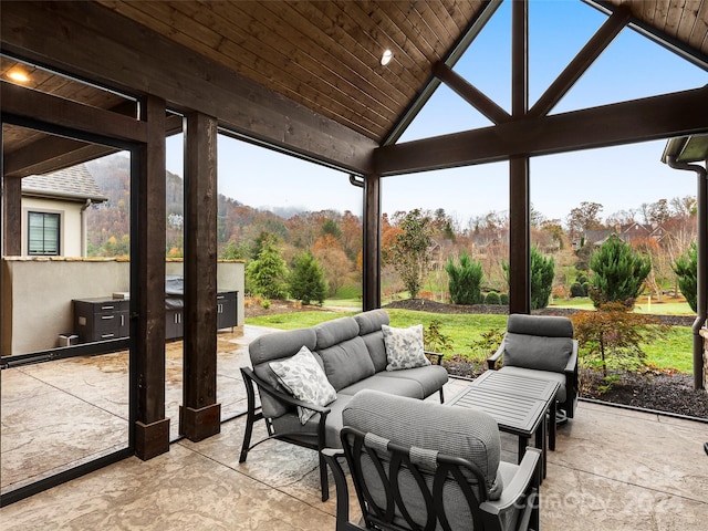 sunroom / solarium featuring vaulted ceiling, a wealth of natural light, and wooden ceiling