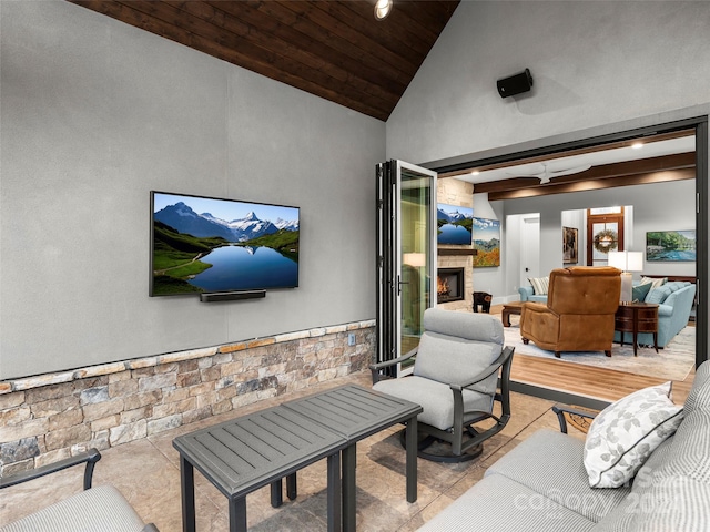 living room featuring lofted ceiling with beams, light tile patterned floors, a fireplace, and wood ceiling