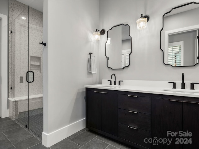 bathroom featuring tile patterned flooring, vanity, and a shower with door