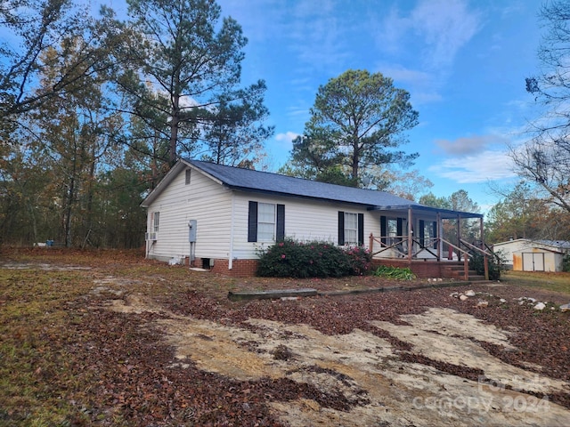 exterior space with a porch and a storage unit