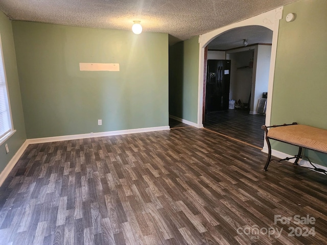 unfurnished room featuring a textured ceiling and dark wood-type flooring