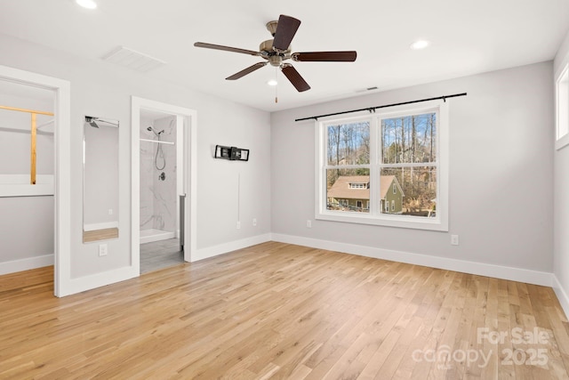 unfurnished bedroom featuring connected bathroom, a spacious closet, light hardwood / wood-style flooring, a closet, and ceiling fan