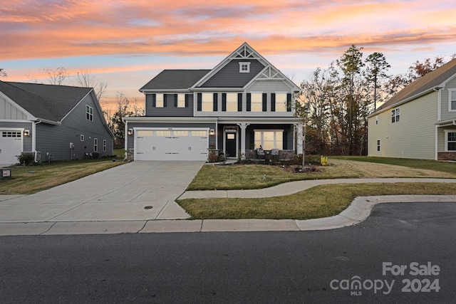 craftsman inspired home with a garage and a yard