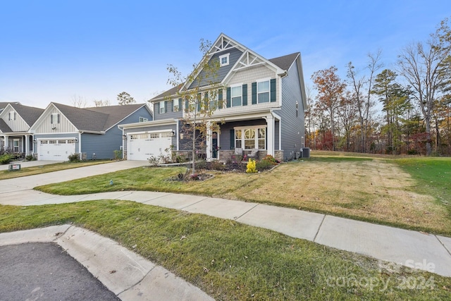 craftsman-style home with central air condition unit, a front lawn, and a garage