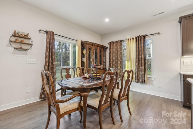 dining space with a wealth of natural light and dark hardwood / wood-style flooring