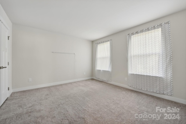 unfurnished room featuring light carpet