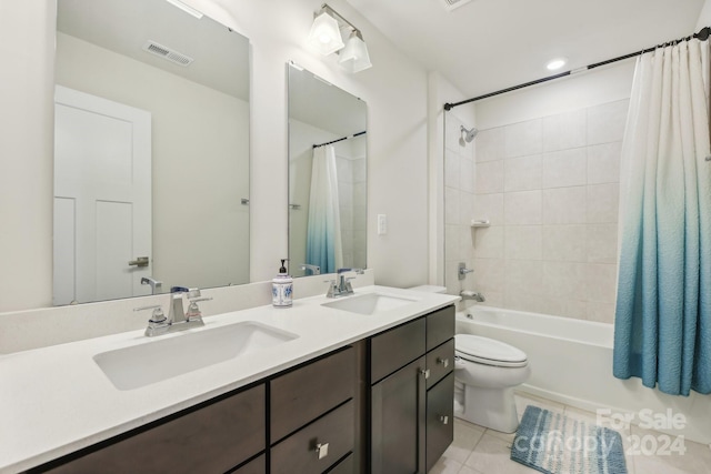 full bathroom featuring toilet, vanity, tile patterned floors, and shower / tub combo with curtain