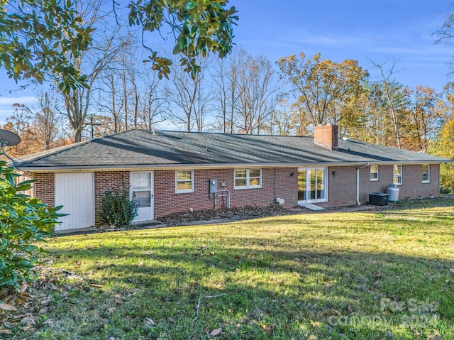 rear view of property featuring a lawn and cooling unit