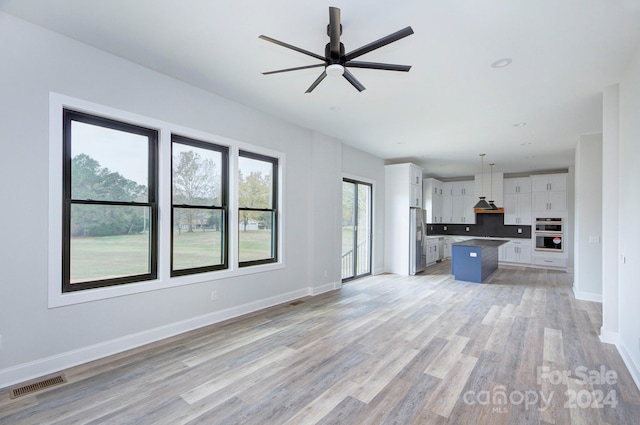 unfurnished living room with ceiling fan and light wood-type flooring