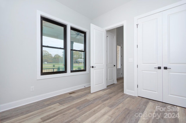 unfurnished bedroom featuring light hardwood / wood-style flooring and a closet