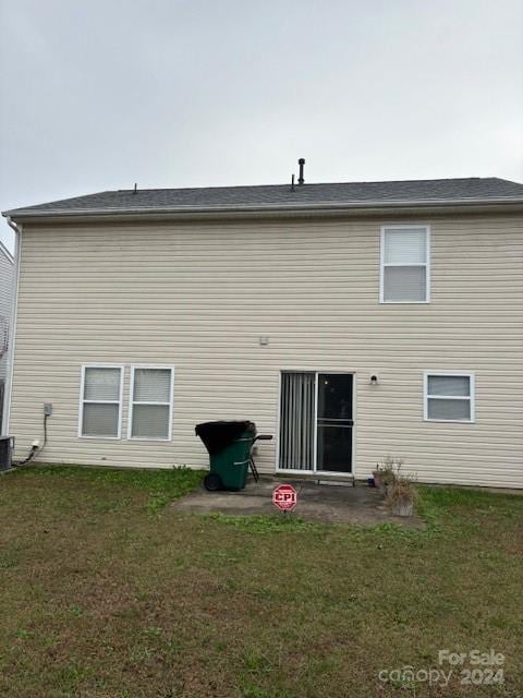 back of house with central air condition unit, a patio area, and a yard