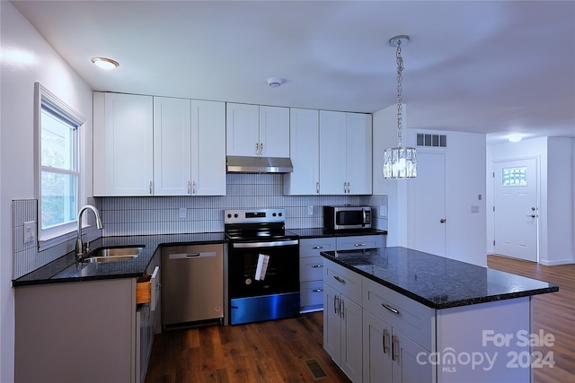 kitchen with sink, stainless steel appliances, dark wood-type flooring, pendant lighting, and white cabinets