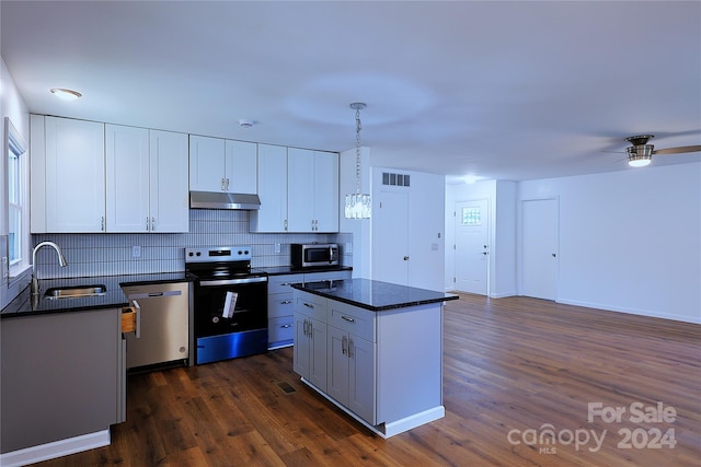 kitchen featuring stainless steel appliances, sink, pendant lighting, white cabinets, and dark hardwood / wood-style floors