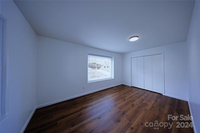 unfurnished bedroom featuring dark hardwood / wood-style floors and a closet