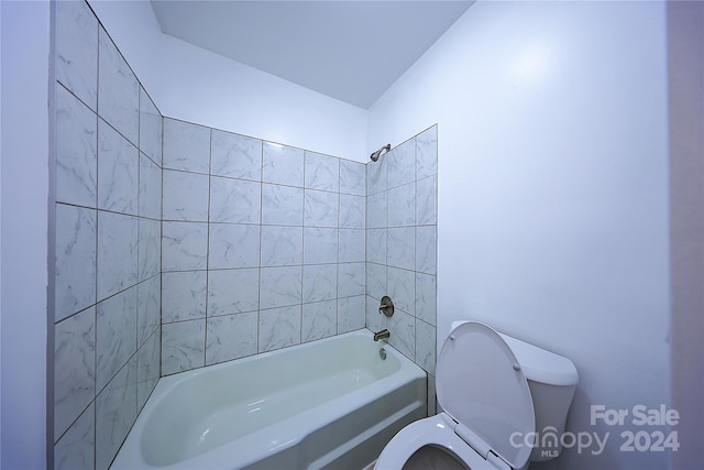 bathroom featuring tiled shower / bath and toilet