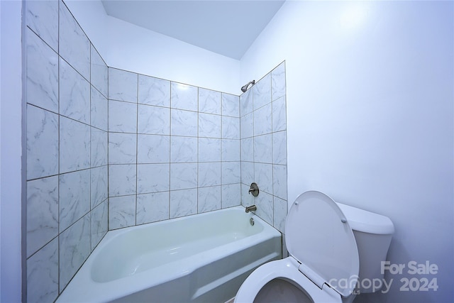 bathroom featuring toilet and tiled shower / bath