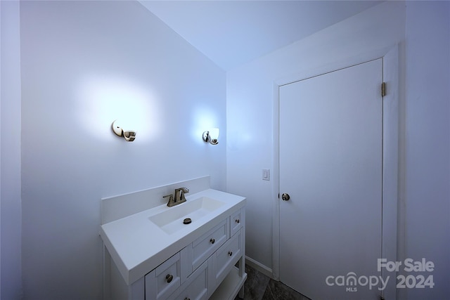 bathroom featuring vanity and lofted ceiling