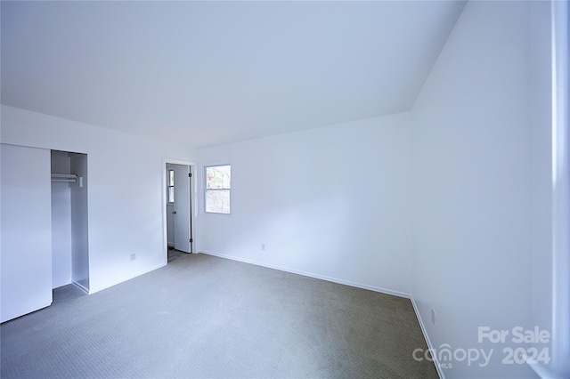 unfurnished bedroom featuring dark carpet and a closet