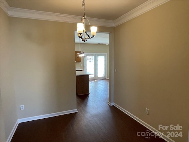 unfurnished dining area featuring a chandelier, french doors, dark hardwood / wood-style floors, and ornamental molding