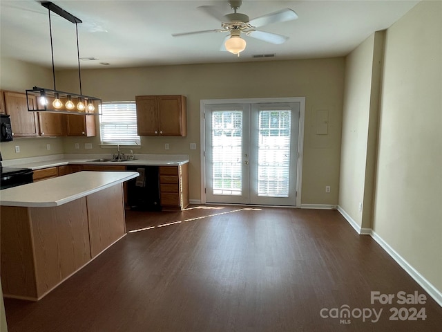 kitchen with pendant lighting, dark hardwood / wood-style flooring, black appliances, and sink