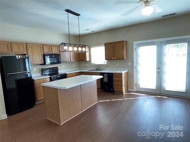 kitchen with black appliances, a kitchen island, a healthy amount of sunlight, and hanging light fixtures