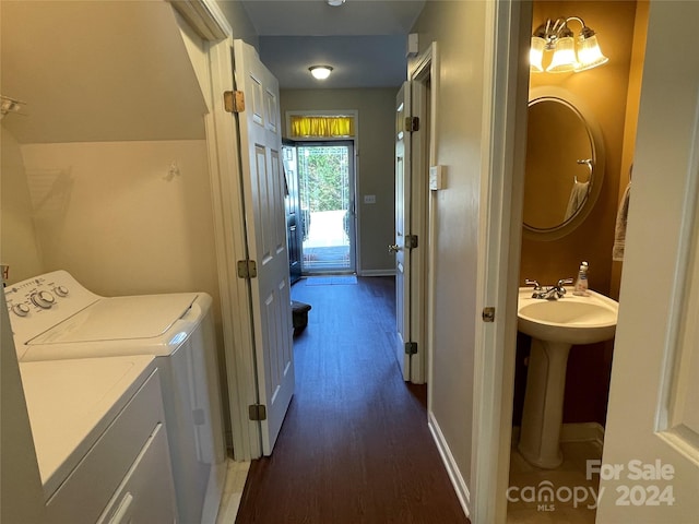 washroom featuring dark hardwood / wood-style flooring, independent washer and dryer, sink, and an inviting chandelier