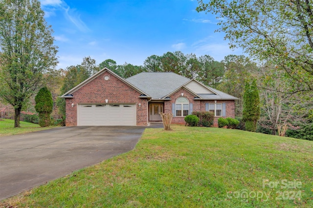 single story home featuring a front lawn and a garage