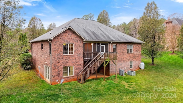 back of property featuring a lawn, a sunroom, cooling unit, and a deck