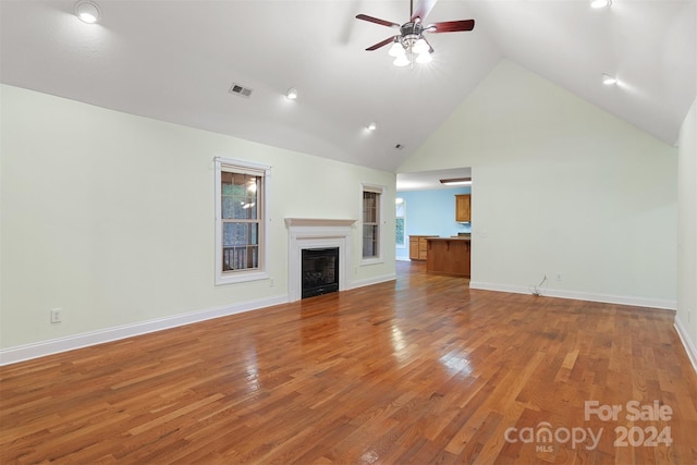 unfurnished living room with ceiling fan, hardwood / wood-style floors, and high vaulted ceiling