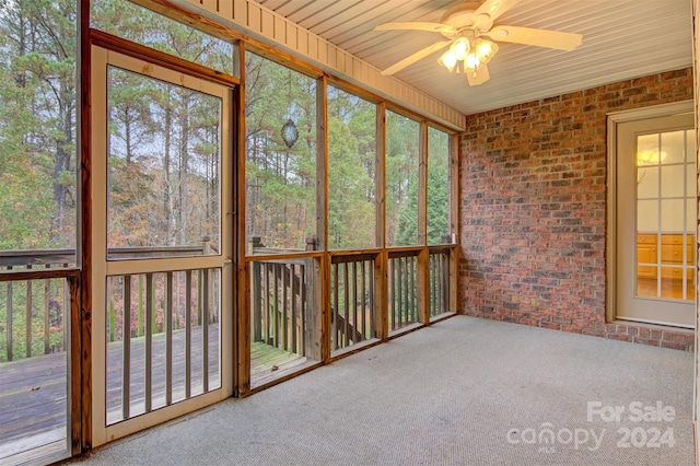 unfurnished sunroom featuring ceiling fan and wooden ceiling