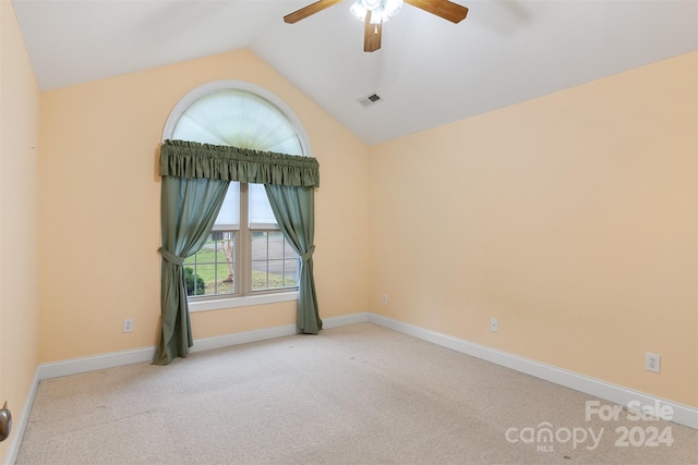 carpeted spare room with ceiling fan and lofted ceiling