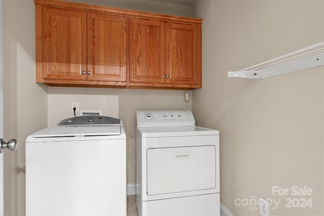 clothes washing area featuring cabinets and washing machine and dryer