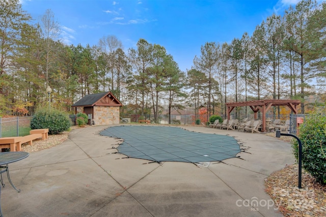 view of pool featuring a pergola, an outdoor structure, and a patio area