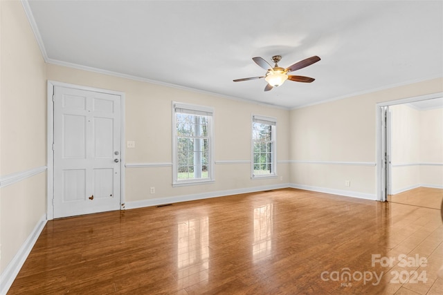 empty room with crown molding, hardwood / wood-style floors, and ceiling fan