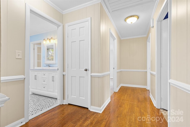 corridor featuring hardwood / wood-style floors, wood walls, and crown molding