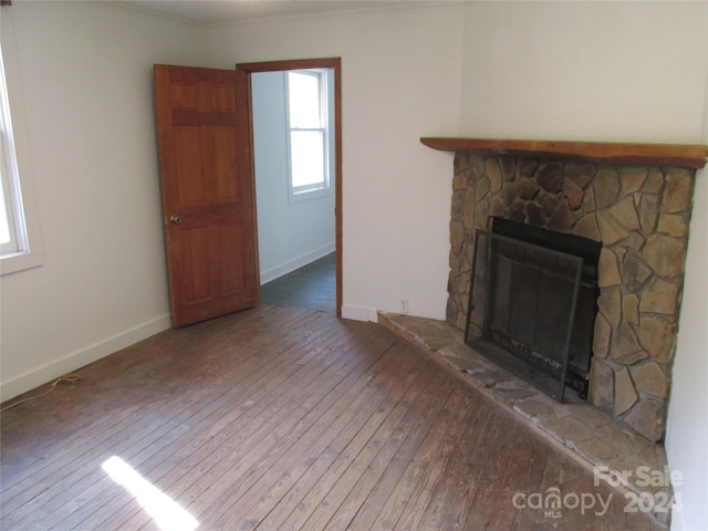 unfurnished living room with hardwood / wood-style flooring, crown molding, and a fireplace