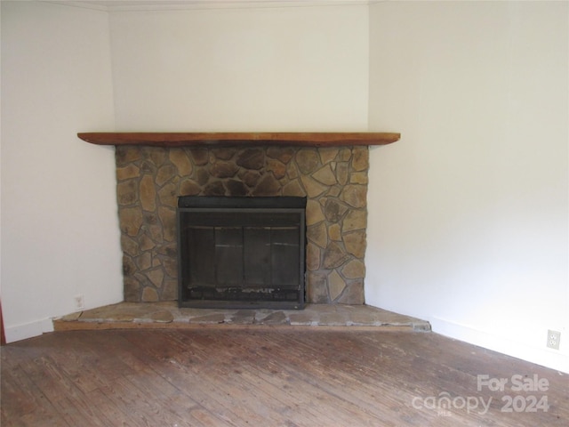 interior details featuring hardwood / wood-style floors and a stone fireplace