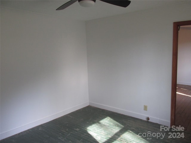 spare room with ceiling fan and dark wood-type flooring