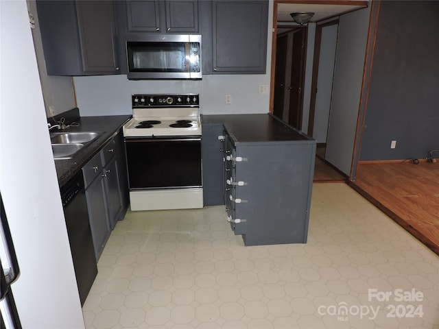 kitchen with dishwashing machine, electric range, light hardwood / wood-style flooring, and sink