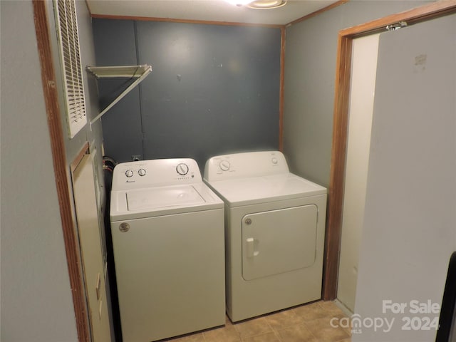 laundry room featuring light tile patterned floors and washer and clothes dryer