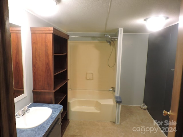 bathroom with a textured ceiling, vanity, and shower / washtub combination