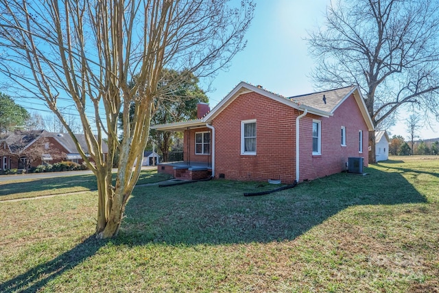 view of side of home featuring cooling unit and a yard