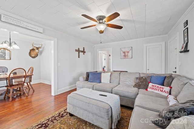 living room featuring crown molding, ceiling fan with notable chandelier, and hardwood / wood-style flooring