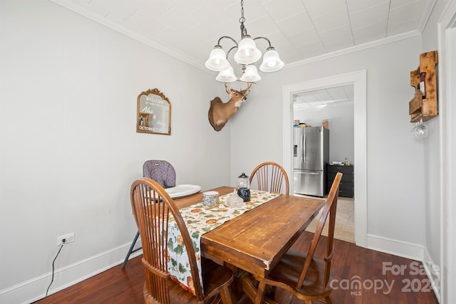 dining space featuring dark hardwood / wood-style floors, crown molding, and a notable chandelier