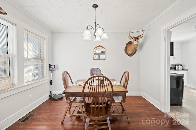 dining space featuring dark hardwood / wood-style flooring, ornamental molding, and a notable chandelier