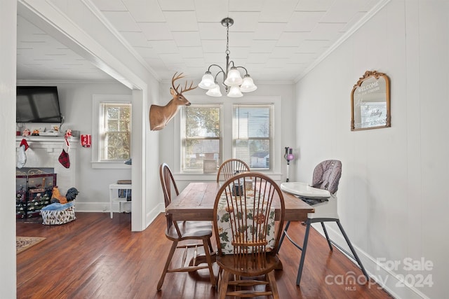 dining room with dark hardwood / wood-style flooring, a chandelier, and ornamental molding